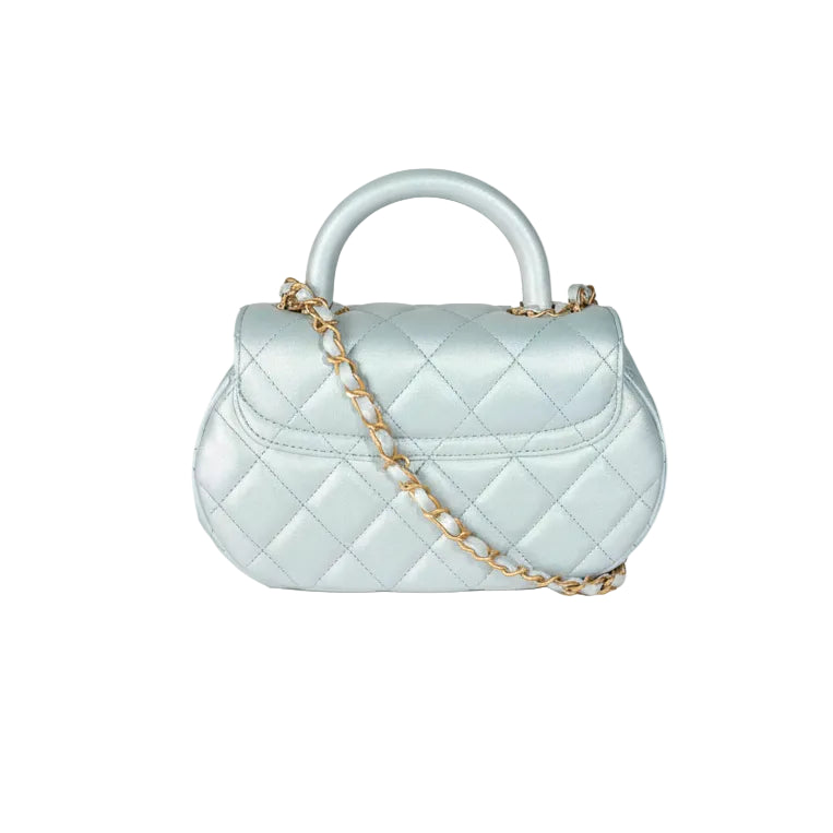 Chanel top handle Light blue quilted handbag with gold hardware on a white background