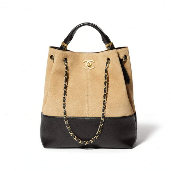Two-Tone Chanel Beige and black Suede handbag with gold chain detail on a white background