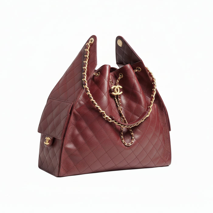 Burgundy Chanel 25 Medium handbag with gold chain and hardware on a white background