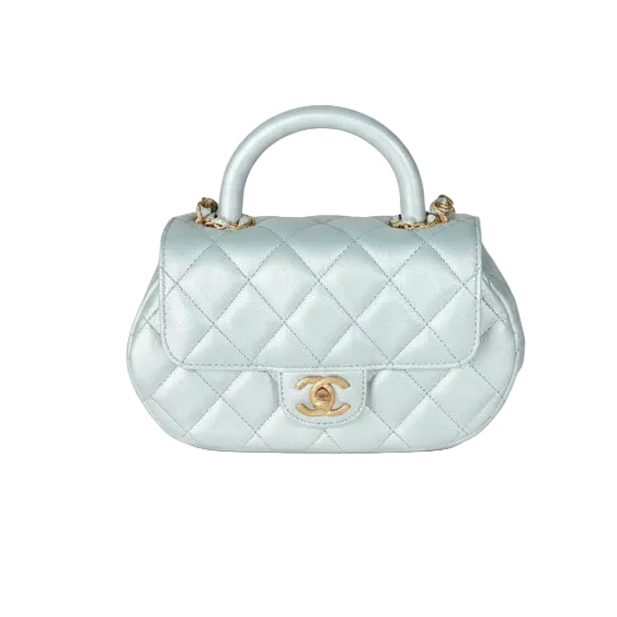 Chanel top handle Light blue quilted handbag with gold hardware on a white background