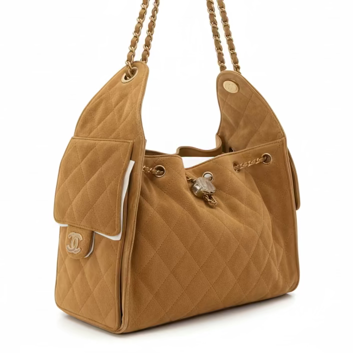 This New, Certified Authentic Chanel 25 Small Hobo Bag is a luxurious and distinctive piece, rendered in soft camel tan quilted suede leather and accented with desirable gold-tone chain and GHW (Gold Hardware).