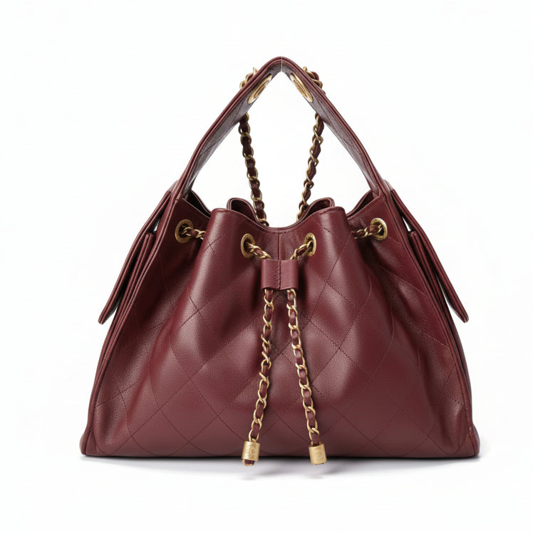 Burgundy Chanel 25 Medium handbag with gold chain and hardware on a white background